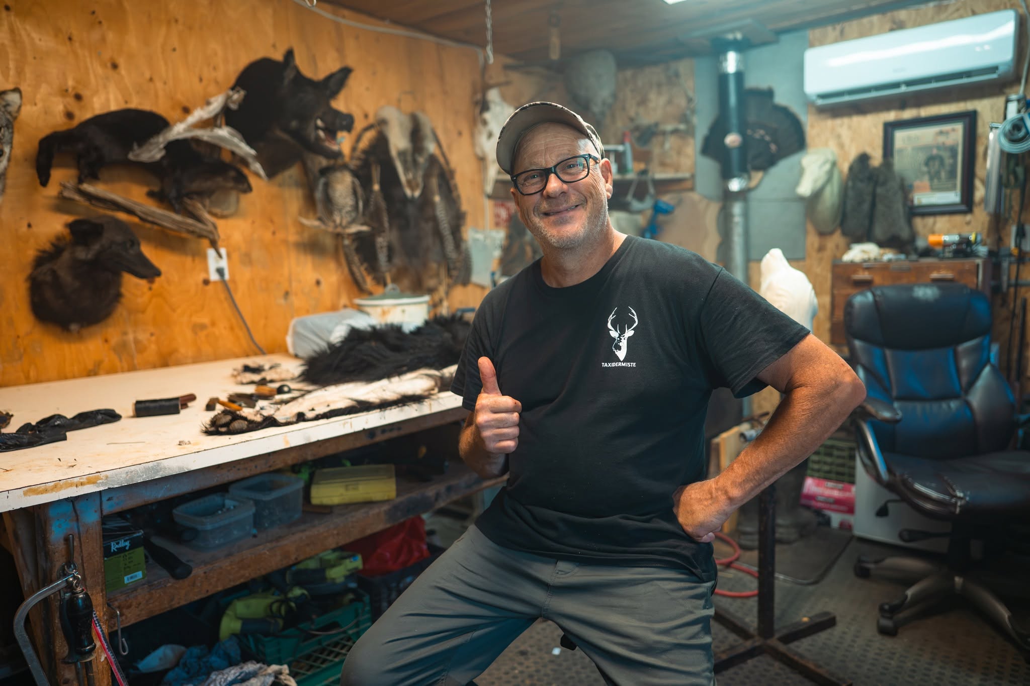 Stéphane Canuel dans son atelier de taxidermie, entouré de montages de renard, de coyote et de crânes